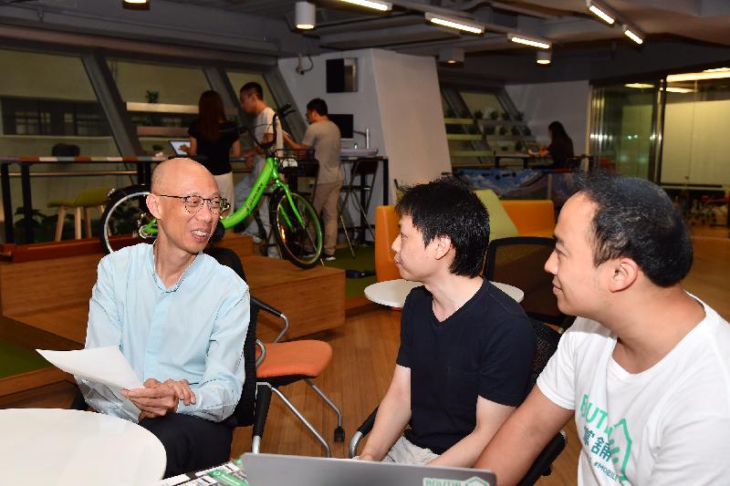 The Secretary for the Environment, Mr Wong Kam-sing (left), visits a co-working space company on Whitfield Road today (June 22) and talks with young entrepreneurs. Mr Wong encouraged them to go green in business to help reduce carbon emissions and waste.