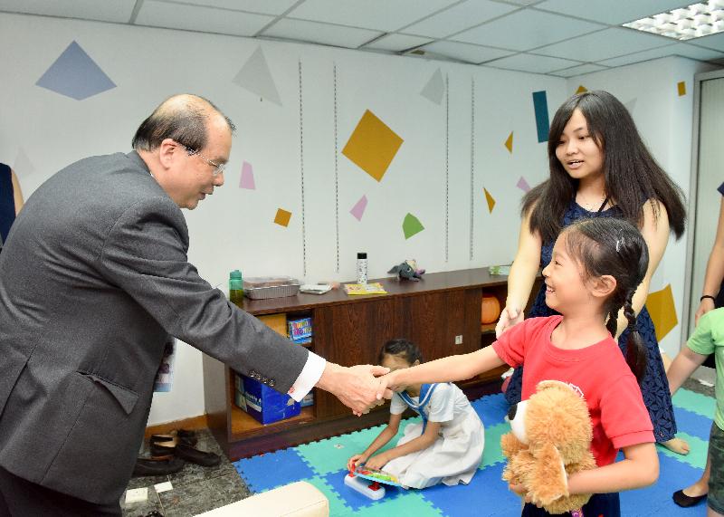 政務司司長張建宗今日（六月二十九日）出席合廠・開幕典禮。圖示張建宗（左一）在「合廠」的兒童遊戲室與一名母親在「合廠」工作的兒童握手。