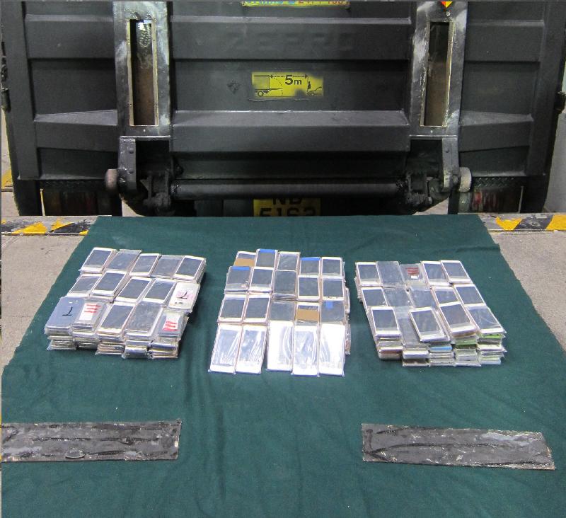 Hong Kong Customs yesterday (July 4) seized a batch of suspected smuggled goods with an estimated market value of about $900,000 from an outgoing lorry at Lok Ma Chau Control Point. Photo shows the suspected smuggled smartphones seized after being found concealed inside a false compartment in the tailgate of the lorry.