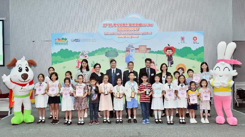 The Acting Director of Health, Dr Wong Ka-hing (back row, centre), the Principal Education Officer (Curriculum Development) of the Education Bureau, Mr Cheng Ming-keung (back row, fifth left),and members of the assessment panel of the Fruit Comic Colouring and Drawing Competition are pictured with winners of the Competition at the EatSmart School Accreditation Ceremony 2018 and Healthy Eating Forum today (July 6).