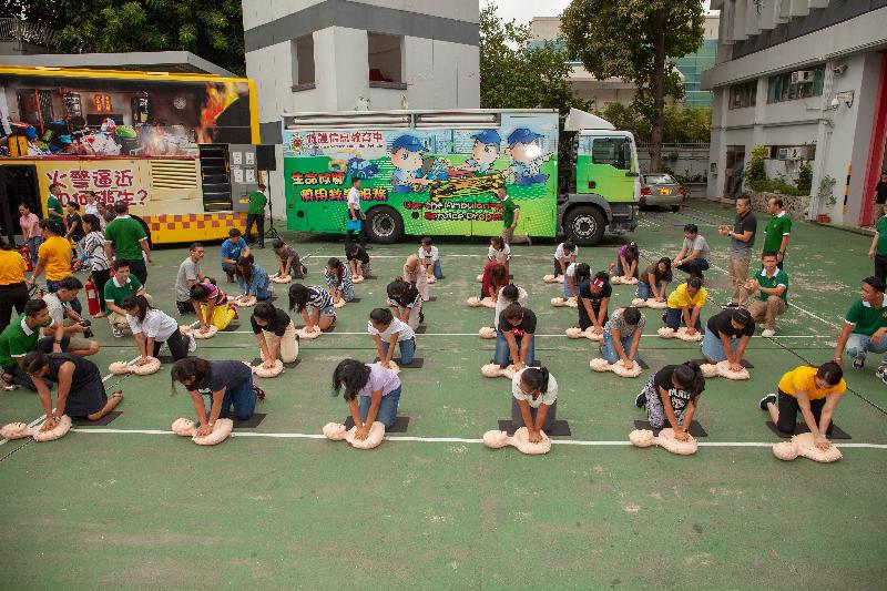 The launch ceremony of the "Fire Safety x Press to Shock, Save a Life" training programme for foreign domestic helpers was held today (July 8) at Sheung Wan Fire Station. Photo shows participants trying out performing cardio pulmonary resuscitation.