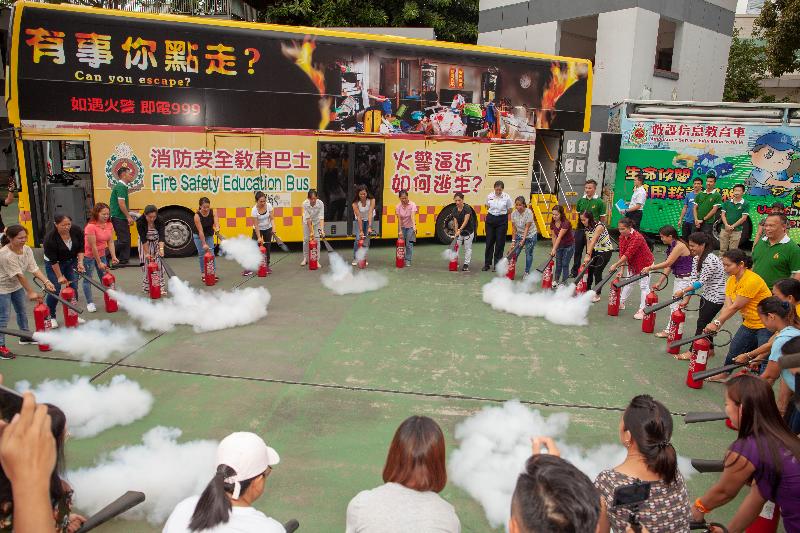 The launch ceremony of the "Fire Safety x Press to Shock, Save a Life" training programme for foreign domestic helpers was held today (July 8) at Sheung Wan Fire Station. Photo shows participants trying out the use of fire extinguishers.