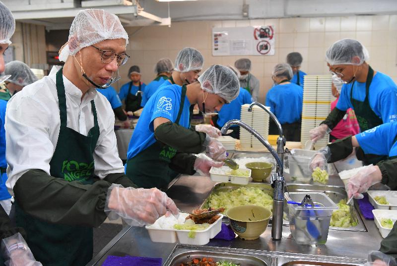 The Secretary for the Environment, Mr Wong Kam-sing (first left), today (July 16) visits Food Angel and prepares lunchboxes together with young volunteers for distributing to the elderly and low-income families for free.