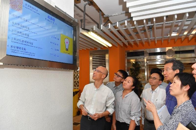 The Secretary for the Environment, Mr Wong Kam-sing (first left), today (July 16) takes a look at the energy monitoring system located at the entrance lobby of Marigold House, So Uk Estate.