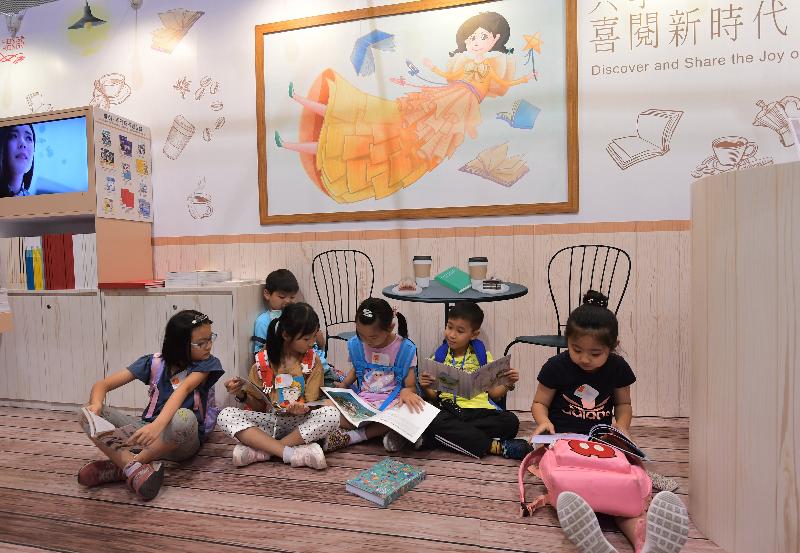 政府新聞處（新聞處）以「共享‧喜閱新時代」為主題，參與今日（七月十八日）至七月二十四日舉行的香港書展。圖示兒童在新聞處攤位閱覽書本，共享閱讀的喜樂。