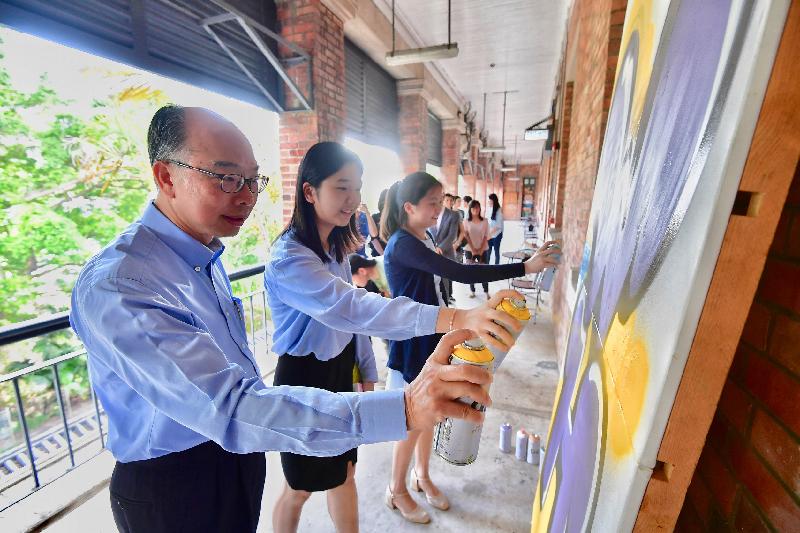 运输及房屋局局长陈帆（左一）今日（七月二十五日）与两名参加「与司局长同行」计划的中学生一同到访南区，参与蒲窝青少年中心的涂鸦活动。