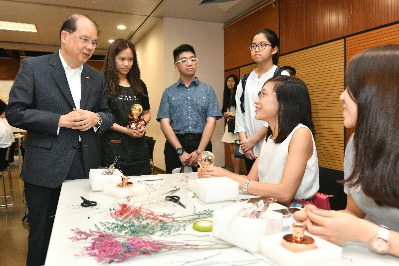The Chief Secretary for Administration, Mr Matthew Cheung Kin-chung (first left), today (July 25) visits Wan Chai and observes a summer activity organised by Wan Chai Teen Horizons of the Wan Chai District Office. Also present are two secondary school students (third and fourth left) participating in the "Be a Government Official for a Day" programme. 