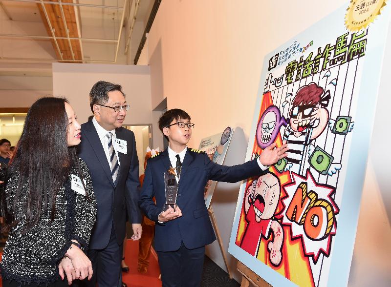 The Commissioner of Police, Mr Lo Wai-chung (centre) and the Vice-Chairman and Chief Executive of Hang Seng Bank, Ms Louisa Cheang (left), viewing the winning piece of file jacket design competition of Hang Seng Bank – Help the Police Fight Youth Crime Competition 2018.
