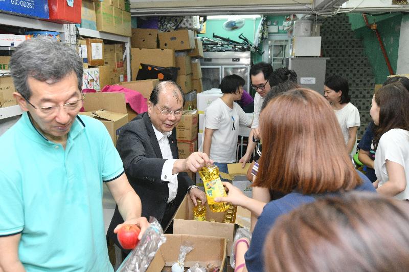 The Chief Secretary for Administration, Mr Matthew Cheung Kin-chung, today (July 31) visited J Life Foundation Limited (Family Service Center). Photo shows Mr Cheung (second left), accompanied by the Chairman of the Sham Shui Po District Council, Mr Ambrose Cheung (first left), distributing food to families receiving services there.