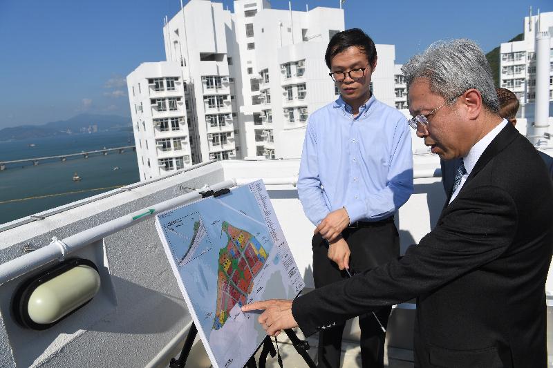 The Secretary for the Civil Service, Mr Joshua Law, today (August 8) visited Islands District and observed from height at Ying Tung Estate in Tung Chung the various infrastructure and development projects. Photo shows Mr Law (right) being briefed on the latest progress of the Tung Chung East reclamation works under the Tung Chung New Town Extension project by a colleague of a related department. 