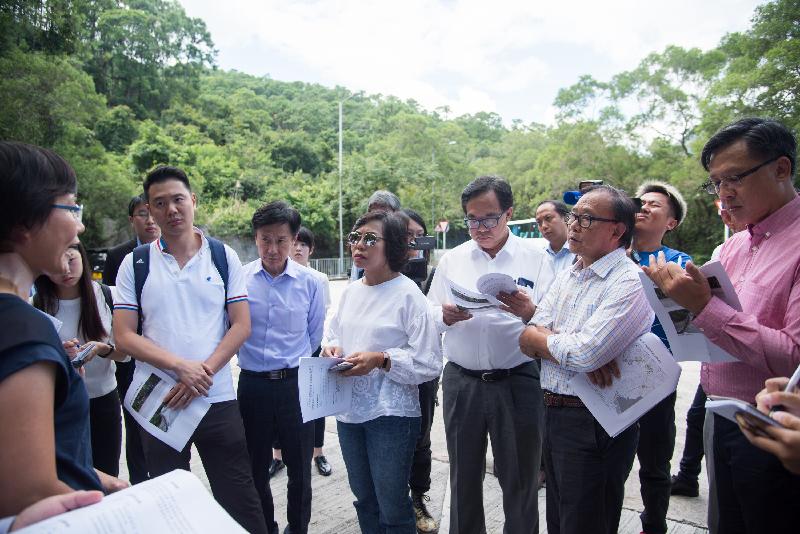 Members of the Legislative Council today (August 8) visited Lantau Island to follow up on a case concerning improvement of the road safety and the traffic network on Lantau Island. Photo shows Members receiving a briefing by a government representative on the road widening and road bend improvement works of Keung Shan Road.