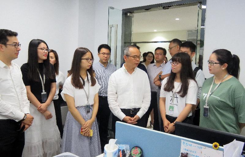 The Chief Secretary for Administration and Chairman of the Youth Development Commission (YDC), Mr Matthew Cheung Kin-chung; the Secretary for Home Affairs, Mr Lau Kong-wah; and YDC members visited Shenzhen today (August 10). Picture shows Mr Lau (front row, fourth left) receiving a briefing by Hong Kong interns on their duties during a tour to an organisation offering entrepreneurship services to small and medium-sized enterprises in Nanshan.