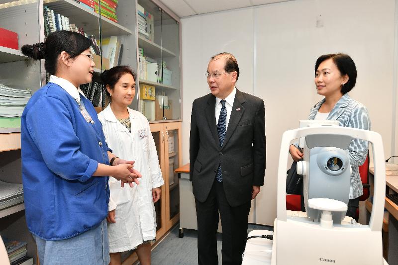 The Chief Secretary for Administration, Mr Matthew Cheung Kin-chung (second right), today (August 14) visits the Wan Chai Elderly Health Centre and is briefed about the retinal examination service provided by the centre for the elderly.