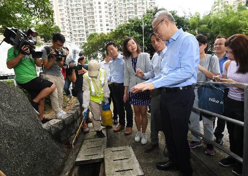 The Under Secretary for Food and Health, Dr Chui Tak-yi (fourth right), and members of the Kwai Tsing District Council inspected the mosquito prevention and control measures carried out in Kwai Tsing District by the Food and Environmental Hygiene Department (FEHD) today (August 16). Photo shows FEHD staff spraying larvicidal oil into drains in the vicinity of Kwai Hau Street, Kwai Chung.