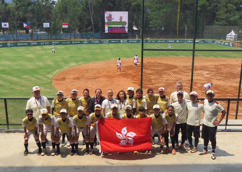 The Secretary for Home Affairs, Mr Lau Kong-wah, today (August 19) watched some of the Asian Games competitions  in which Hong Kong athletes are participating in Jakarta, Indonesia. Photo shows Mr Lau (back row, sixth left) taking a group photo with Hong Kong women's softball team after watching a match.