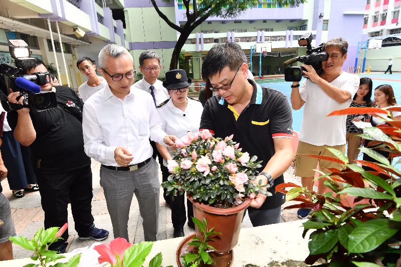 The Acting Secretary for Food and Health, Dr Chui Tak-yi (front left), visited a school in Wong Tai Sin today (August 24) to see the mosquito preventive work in the school premises before the start of the new school year. Photo shows Food and Environmental Hygiene Department staff reminding the school staff to eliminate the water in plant pot saucers at least once a week.