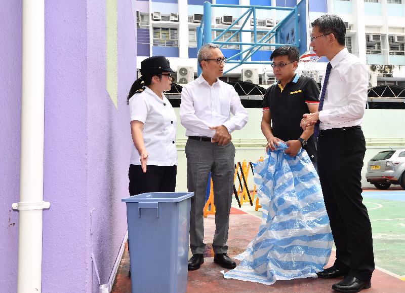The Acting Secretary for Food and Health, Dr Chui Tak-yi (second left), visited a school in Wong Tai Sin today (August 24) to see the mosquito preventive work in the school premises before the start of the new school year. Photo shows Food and Environmental Hygiene Department staff advising the school staff to cover all containers to prevent accumulation of water. 