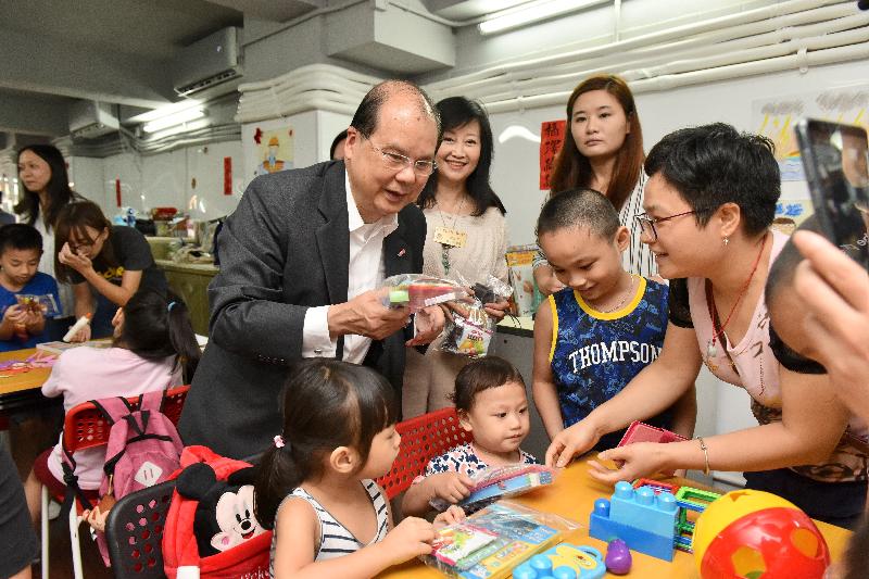 The Chief Secretary for Administration, Mr Matthew Cheung Kin-chung, today (August 24) visited the Co-Sharing Services Centre under the Lok Sin Tong Social Housing Scheme in Kowloon City District. Photo shows Mr Cheung (back row, left), accompanied by the  first Vice-chairlady of the Lok Sin Tong Benevolent Society, Kowloon, Dr Yang Xiao-ling (back row, centre), giving out gifts to  children in the Centre.