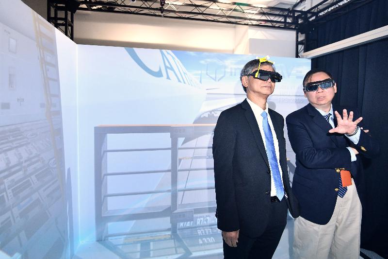 The Secretary for Labour and Welfare, Dr Law Chi-kwong, visited the Logistics and Supply Chain MultiTech R&D Centre (LSCM) today (August 27). Photo shows Dr Law (left) and the Chief Executive Officer of the LSCM, Mr Simon Wong (right), wearing virtual reality spectacles in a simulation of training operations on airport facilities.