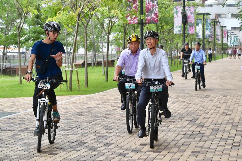 The Secretary for the Environment, Mr Wong Kam-sing (third left), takes a bicycle ride today (August 27) when visiting the Kwun Tong Promenade to see the trial greenway for cyclists and pedestrians.