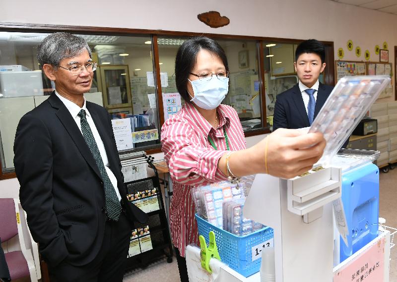 The Secretary for Labour and Welfare, Dr Law Chi-kwong, called at Chi Lin Care and Attention Home and Chi Lin Day Care Centre for the Elderly at noon today (August 28) and visited elderly persons. Photo shows Dr Law (left) watching staff demonstrating the use of the automated drug-dispensing system.