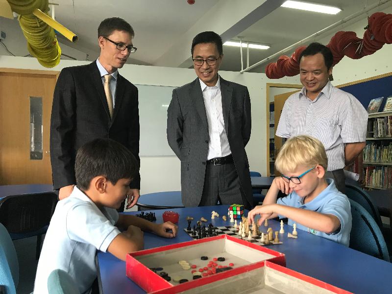 The Secretary for Education, Mr Kevin Yeung, paid a duty visit to Zhuhai and Zhongshan in Guangdong Province today (August 29). Photo shows Mr Yeung (centre) and the Director of the Zhuhai Education Bureau, Mr Lin Rituan (right), watching two students playing chess at the library of Zhuhai International School.