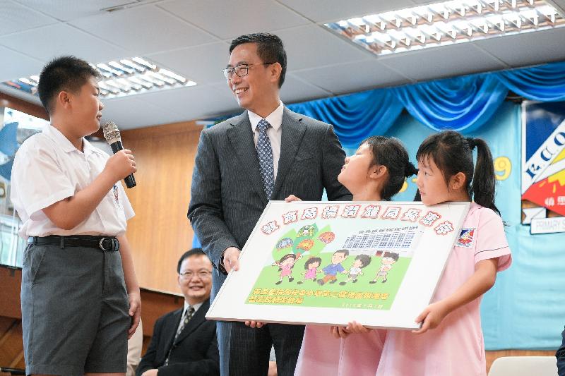 教育局局長楊潤雄（左二）今日（九月三日）在英皇書院同學會小學第二校開學禮上獲同學送贈一幅畫作。