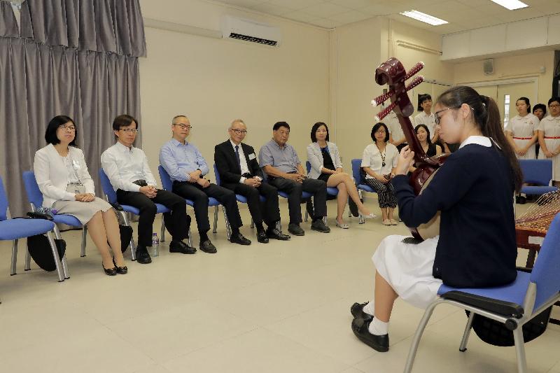 The Secretary for Home Affairs, Mr Lau Kong-wah (third left), watches a performance by a member of the Chinese orchestra during his visit to TWGHs Li Ka Shing College in North District today (September 6).