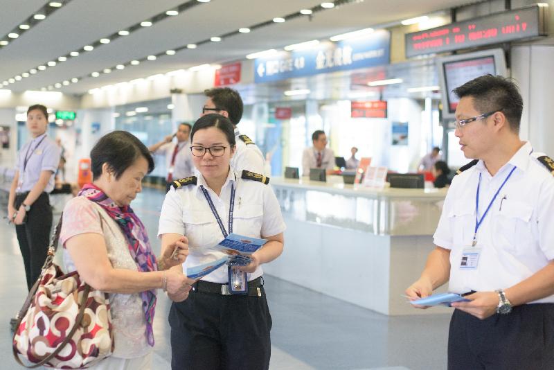 Marine Inspectors of the Marine Department distribute promotional leaflets to passengers at the waiting lounge of the Hong Kong-Macau Ferry Terminal in Sheung Wan today (September 7) to encourage them to fasten their seat belts at the appropriate time to ensure a safer sea journey.
