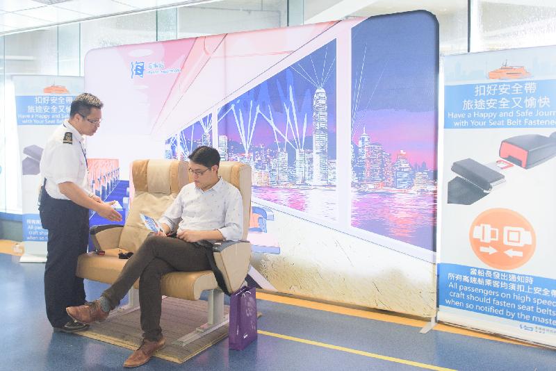 The Marine Department today (September 7) set up a large backdrop of Hong Kong scenery decorated with genuine cabin seats at the waiting lounge of the Hong Kong-Macau Ferry Terminal in Sheung Wan. Photo shows a passenger trying the seats with his seat belt fastened.
