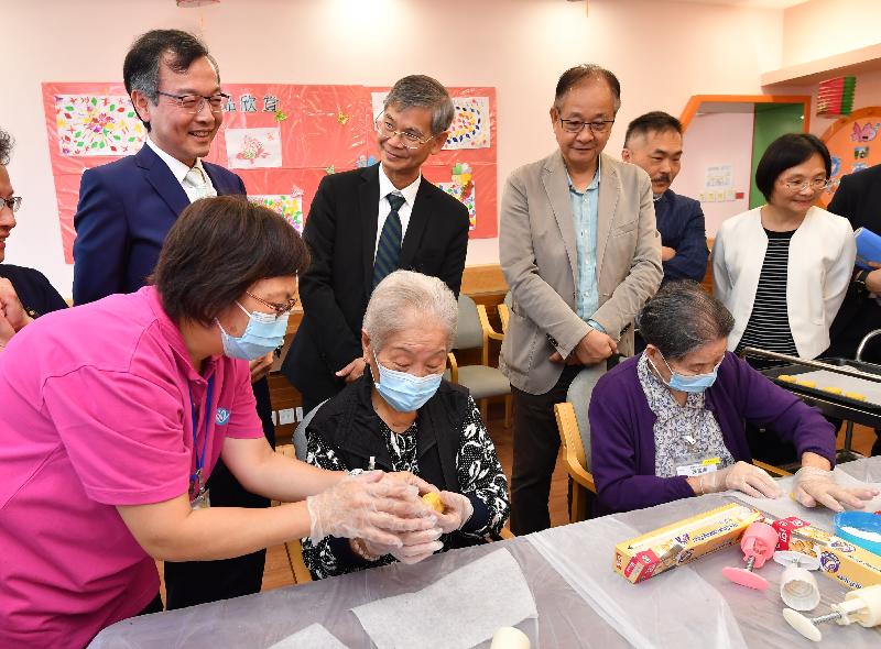 The Secretary for Labour and Welfare, Dr Law Chi-kwong, today (September 13) visited Sai Kung District and called at the Haven of Hope Tsui Lam Day Training Centre for the Elderly of Haven of Hope Christian Service (HOHCS). Photo shows (back row, from left) the Chief Executive Officer of HOHCS, Dr Lam Ching-choi; Dr Law; the Chairman of the Sai Kung District Council, Mr George Ng; the District Officer (Sai Kung), Mr David Chiu; and the District Social Welfare Officer (Wong Tai Sin/Sai Kung), Ms Micy Lui, watching elderly persons learning to make mooncakes for the Mid-Autumn Festival.
