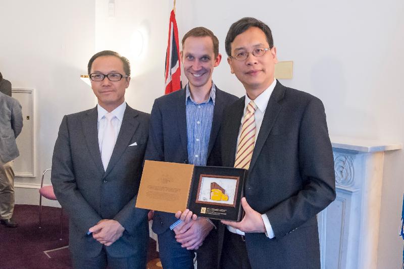 The leader of the delegation of the Legislative Council, Mr Ip Kin-yuen (right), along with the duty leader Mr Kenneth Leung (left), present a souvenir to the Head of Defence and International Policy (Scotland) of the Scotland Office of the Government of the United Kingdom, Mr Nigel Patrick (centre).