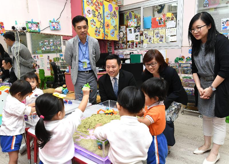 The Acting Secretary for Labour and Welfare, Mr Caspar Tsui, visited Causeway Bay Child Care Centre of St James' Settlement today (September 18) and sent his regards to personnel for their commitment during the passage of the typhoon for supporting members of the public and service users. Photo shows Mr Tsui (back row, second left) and the District Social Welfare Officer (Eastern and Wan Chai), Miss Hannah Yip (back row, third left), watching children playing with kinetic sand as sensory training.