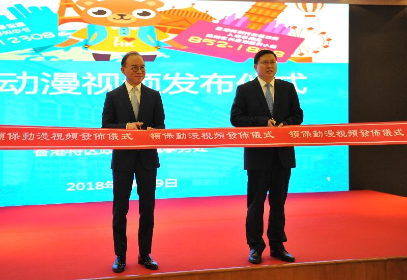 Deputy Commissioner of the Office of the Commissioner of the Ministry of Foreign Affairs of the People's Republic of China in the Hong Kong Special Administrative Region (OCMFA) Mr Song Ru'an (right) and the Director of Immigration, Mr Tsang Kwok-wai (left), officiate at the ribbon-cutting ceremony of the Launching Ceremony of an Animated Video on Consular Protection at the OCMFA today (September 19). 