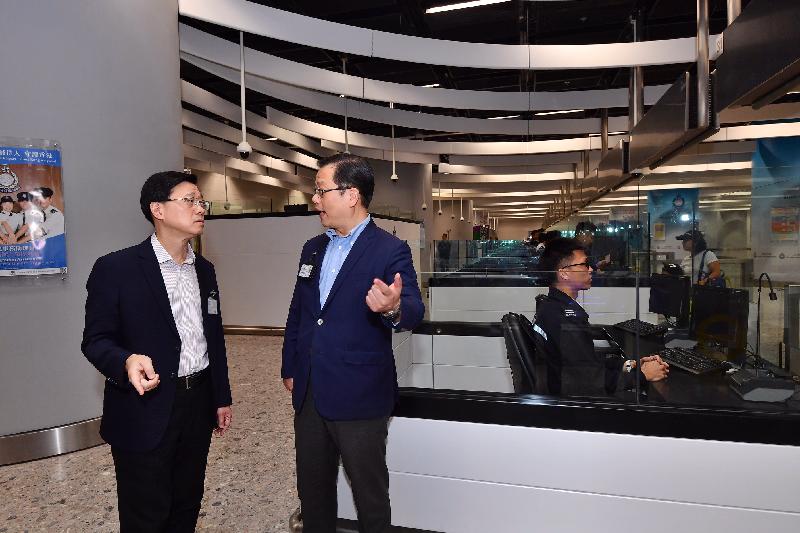 The Secretary for Security, Mr John Lee (first left),  visits the duty room of the Immigration Department at  the Hong Kong Port Area  of WKS and also  sees for himself the procedure of entry and departure clearance for passengers  today (September 23). 