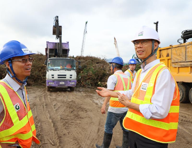 The Secretary for the Environment, Mr Wong Kam-sing (right), visits an area set aside for temporary wood waste collection in the Kai Tak Development Area this afternoon (September 24) to learn more about its operation.