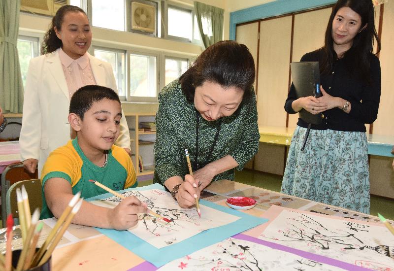 The Secretary for Justice, Ms Teresa Cheng, SC, visits Islamic Dharwood Pau Memorial Primary School in Wong Tai Sin District today (September 26). Photo shows Ms Cheng (second right) painting a picture with a student.