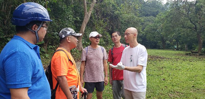 Accompanied by the Director of Agriculture, Fisheries and Conservation, Dr Leung Siu-fai (first left), the Secretary for the Environment, Mr Wong Kam-sing (first right), visited Shing Mun Country Park today (September 27), where he is pictured chatting with hikers.