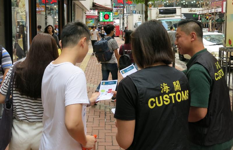 香港海关今日（九月二十八日）展开「极光」行动，在「国庆黄金周」期间加强巡查，以保障消费者。图示海关人员在铜锣湾派发宣传单张。