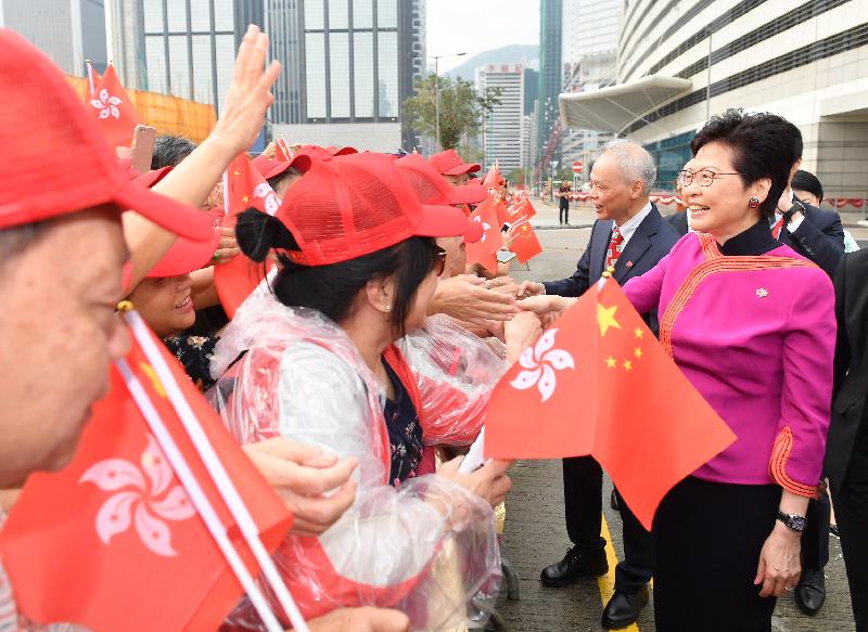 The Chief Executive, Mrs Carrie Lam (first right), greets members of the public before attending the flag-raising ceremony in celebration of the 69th anniversary of the founding of the People's Republic of China at Golden Bauhinia Square in Wan Chai this morning (October 1). Joining her is her husband Dr Lam Siu-por (second right).
