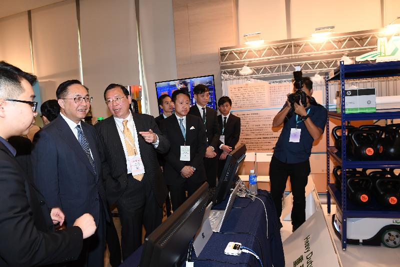 The Secretary for Innovation and Technology, Mr Nicholas W Yang (second left), receives a briefing by the Chief Executive Officer of the Logistics and Supply Chain MultiTech R&D Centre (LSCM), Mr Simon Wong (third left), on heavy duty autonomous guided vehicles (AGVs) at the LSCM Logistics Summit 2018 today (October 5). The AGVs, using mobile robots and an AGV management system, implement automated warehouse functions and enhance warehouse management efficiency.