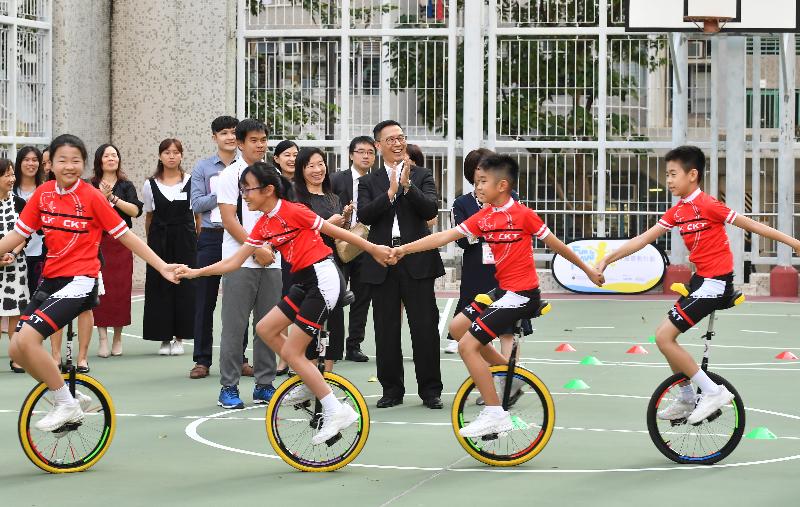 During his visit to PLK Chong Kee Ting Primary School in Sha Tin today (October 8), the Secretary for Education, Mr Kevin Yeung (centre), watches a students' performance of unicycling.