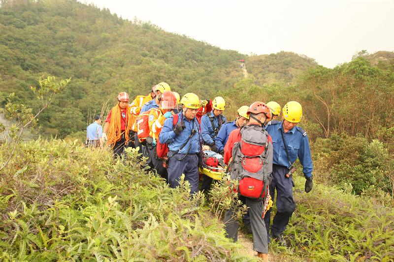 消防处人员在今日（十月十日）举行的跨部门山火暨攀山拯救行动演习中模拟拯救一名伤者。
