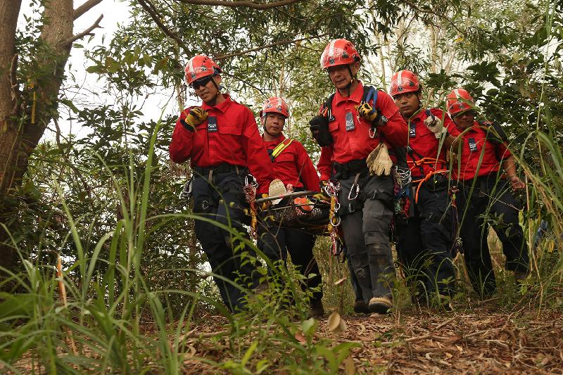 民眾安全服務隊人員在今日（十月十日）舉行的跨部門山火暨攀山拯救行動演習中模擬拯救一名傷者。
