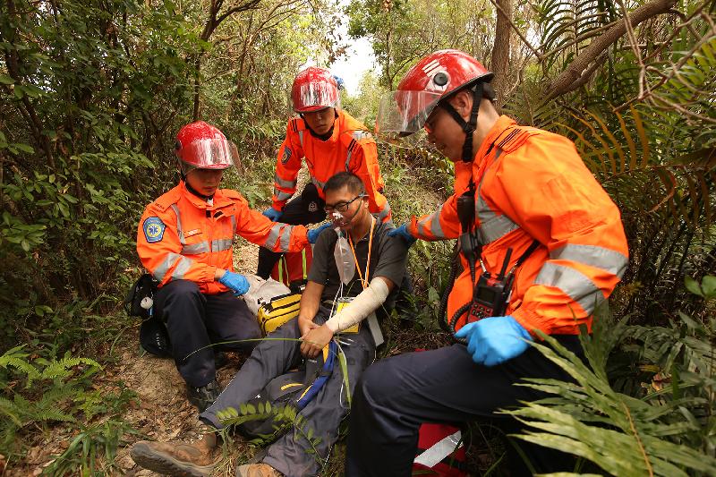 Ambulance personnel handle an injured person during an inter-departmental vegetation fire and mountain rescue operation exercise today (October 10).