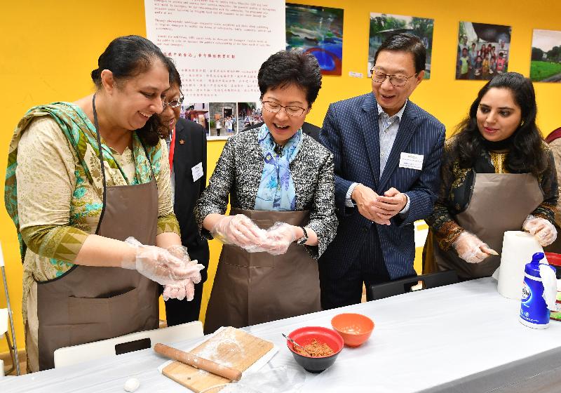 The Chief Executive, Mrs Carrie Lam, visited the LINK Support Service Centre for Ethnic Minorities (LINK Centre) to introduce to them support measures for ethnic minorities in the Policy Address and inspected the site of the District Health Centre in Kwai Tsing District in the morning today (October 13). Picture shows Mrs Lam (third right) making glutinous rice balls with the women in an interest class.