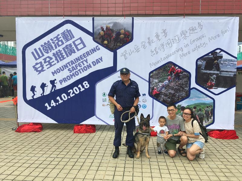 The Civil Aid Service held the Mountaineering Safety Promotion Day 2018 with various government departments and mountaineering organisations today (October 14) at Tuen Mun Cultural Square. Photo shows visitors taking picture with a Police dog.