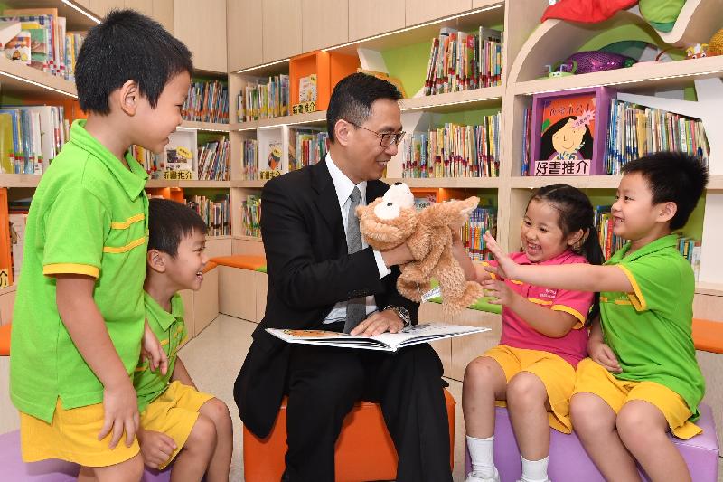 教育局局長楊潤雄（中）今日（十月十八日）在探訪東華三院田灣（一九九六至一九九七總理）幼稚園期間，參與學童的閱讀活動。