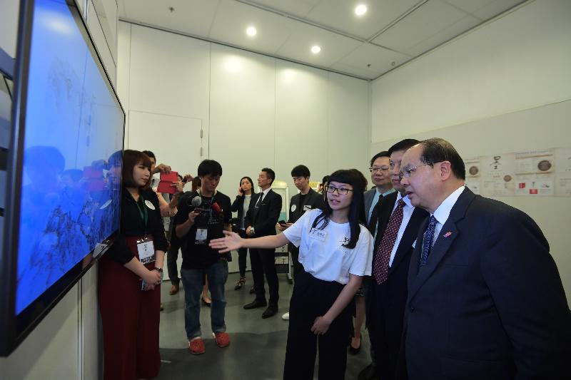 署理行政长官张建宗今日（十月二十四日）出席「全球水墨画大展──教育篇」。图示张建宗（右）听取工作人员介绍展览，