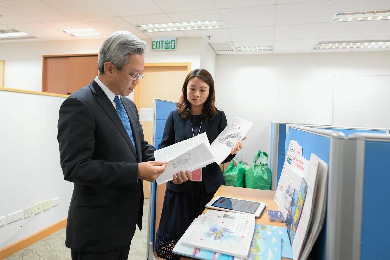 The Secretary for the Civil Service, Mr Joshua Law, visited Invest Hong Kong today (October 26). Photo shows Mr Law (left) being briefed by a colleague on the marketing strategy and promotional campaign of the department.